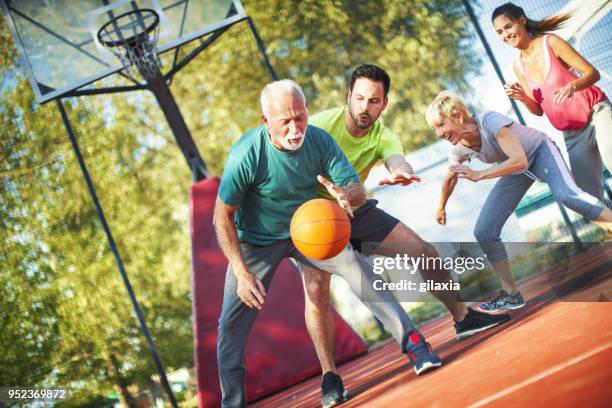 basketball game with family. - mature men playing basketball stock pictures, royalty-free photos & images