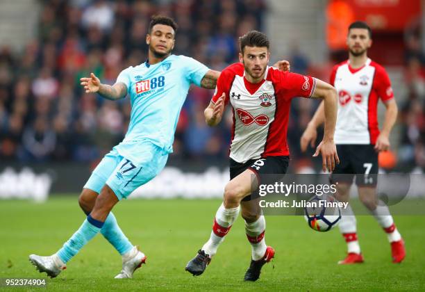 Wesley Hoedt of Southampton runs with the ball under pressure from Joshua King of AFC Bournemouth during the Premier League match between Southampton...