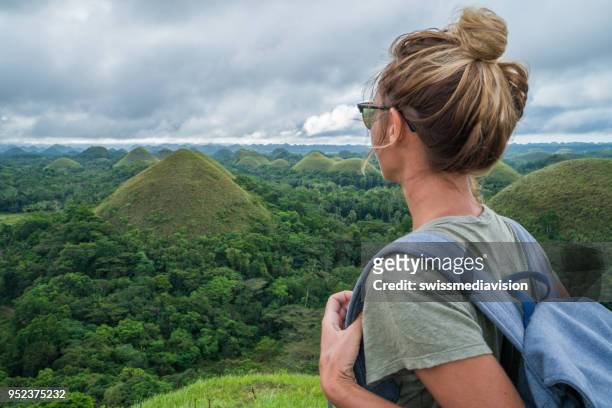 girl traveling contemplates chocolate hills of bohol, philippines - bohol philippines stock pictures, royalty-free photos & images