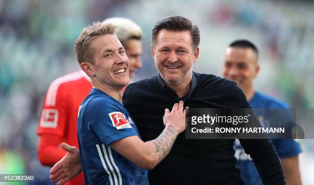 Hamburg's German midfielder Lewis Holtby and Hamburg's German head coach Christian Titz celebrate after the German first division Bundesliga football...