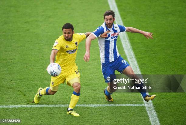 Andy Barcham of AFC Wimbledon battles with Will Grigg of Wigan Athletic during the Sky Bet League One match between Wigan Athletic and A.F.C....