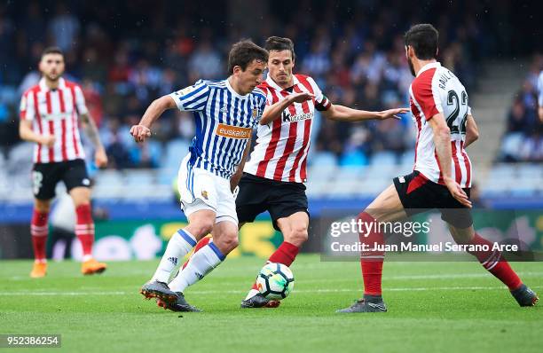 David Zurutuza of Real Sociedad being followed by Ander Iturraspe of Athletic Club Raul Garcia of Athletic Club during the La Liga match between Real...