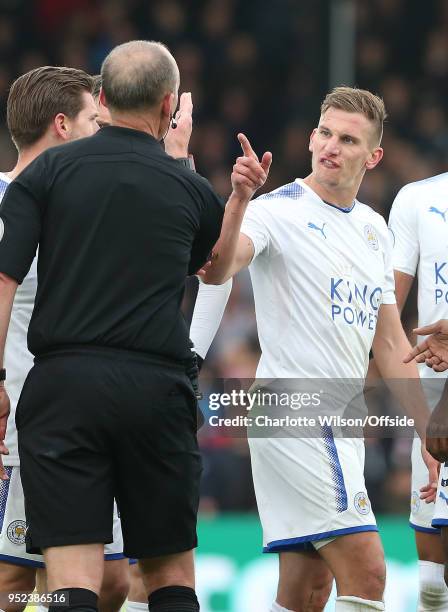 Marc Albrighton of Leicester argues with referee Mike Dean after he is shown a red card during the Premier League match between Crystal Palace and...