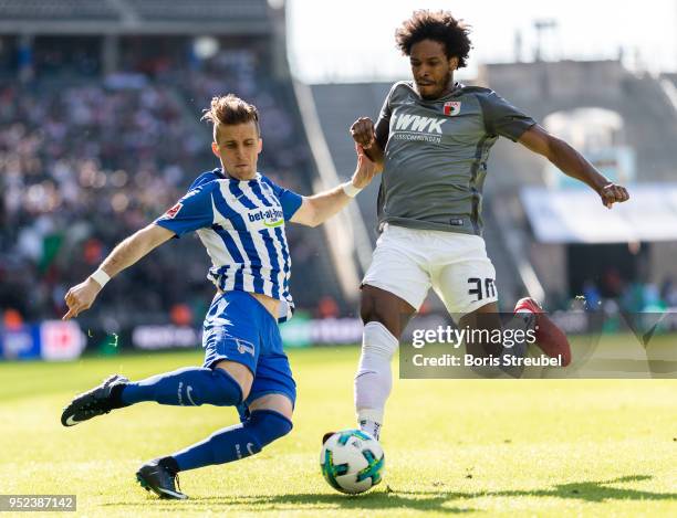 Caiuby Francisco da Silva of FC Augsburg is tackled by Peter Pekarik of Hertha BSC during the Bundesliga match between Hertha BSC and FC Augsburg at...