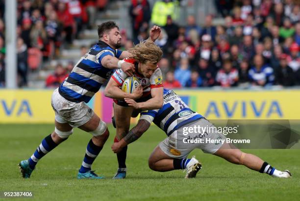 Billy Twelvetrees of Gloucester tackled by Elliott Stooke and Anthony Perenise of Bath during the Aviva Premiership match between Gloucester Rugby...