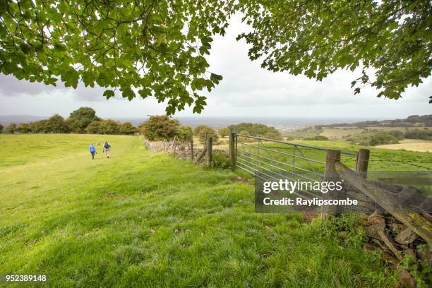 zwei wanderer, abbau in der ansicht über die cotswold-landschaft auf ihrem weg vom broadway tower - broadway worcestershire stock-fotos und bilder