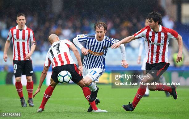 David Zurutuza of Real Sociedad bieng fouled by Mikel Rico of Athletic Club and Mikel San Jose of Athletic Club during the La Liga match between Real...