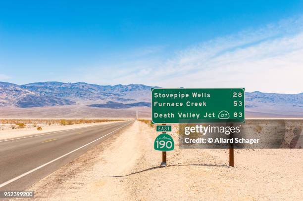 directional sign to destinations in death valley california usa - death valley road stock-fotos und bilder