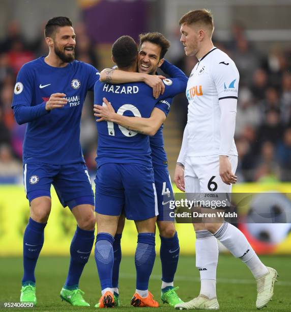 Cesc Fabregas of Chelsea celebrates with teammates Olivier Giroud and Eden Hazard after scoring his sides first goal during the Premier League match...