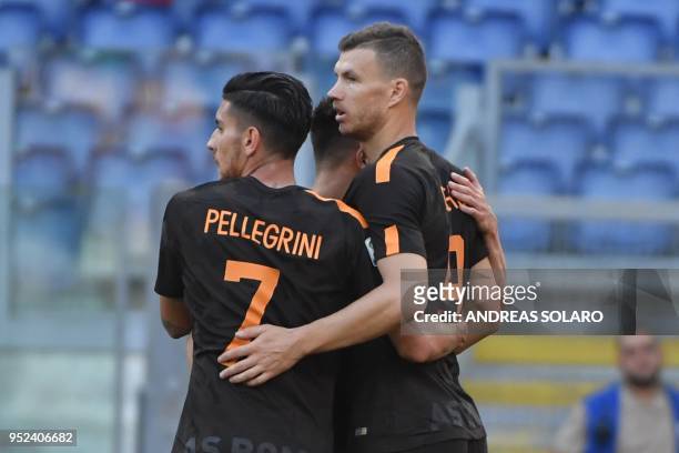 Roma's Bosnian striker Edin Dzeko celebrates with his team mates after scoring during the Italian Serie A football match Roma vs Chievo, on April 28,...