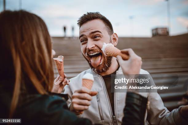 beautiful couple eating ice cream in autumn - couple face to face stock pictures, royalty-free photos & images