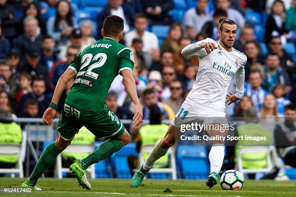 Gareth Bale of Real Madrid competes for the ball with Dimitrios Siovas of Leganes during the La Liga match between Real Madrid and Leganes at Estadio...