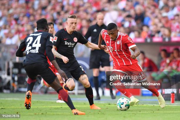 Franck Evina of Bayern Muenchen and Marius Wolf of Frankfurt compete for the ball during the Bundesliga match between FC Bayern Muenchen and...