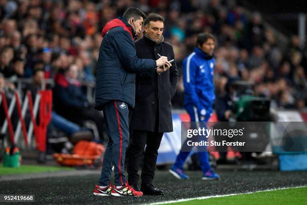 Carlos Carvalhal, Manager of Swansea City receives notes during the Premier League match between Swansea City and Chelsea at Liberty Stadium on April...