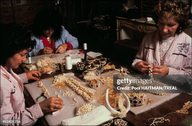 Worker stringing the celebrated Chanel pearl necklace.