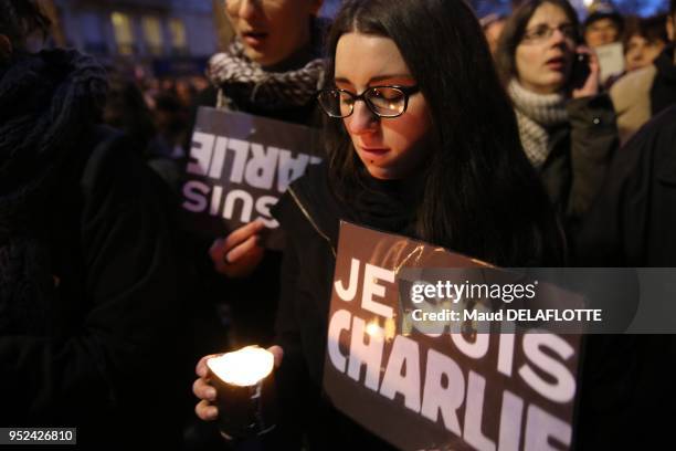 Femme avec une bougie et une affiche 'Je suis Charlie' lors de la marche républicaine pour rendre hommage aux victimes des attentats contre Charlie...