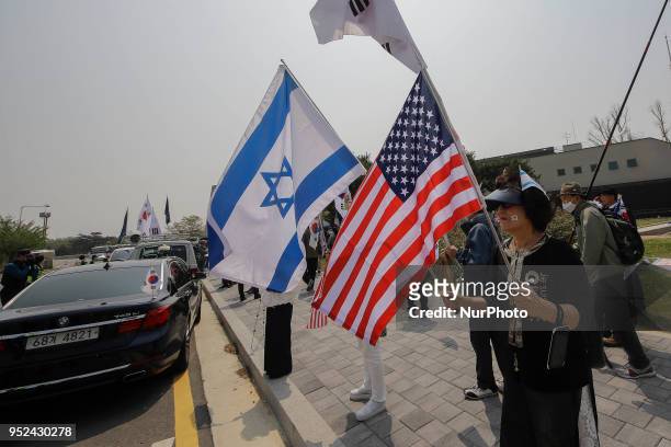 South Korean conservation group members hold U.S and israel flag with shout slogans held on anti-summit protest at imjingak pavilion near unification...