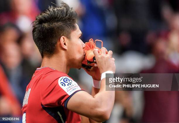 Lille's Brazilian forward Luiz Araujo kisses his shoe as he celebrates after scoring a goal during the French L1 football match between Lille and...