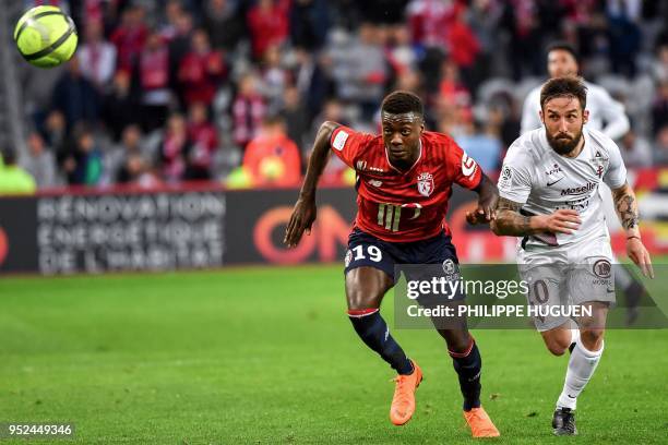 Lille's Ivorian forward Nicolas Pepe and Metz's Luxemburg defender Vahid Selimovic eye the ball during the French L1 football match between Lille and...