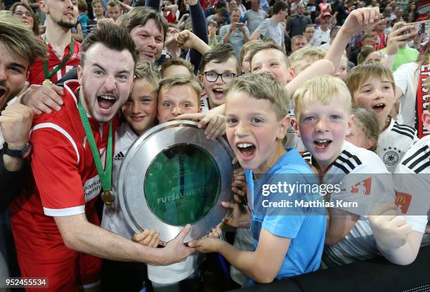 Players and supporters of Hohenstein Ernstthal celebrate with the trophy after winning the German Futsal Championship final match between VfL...