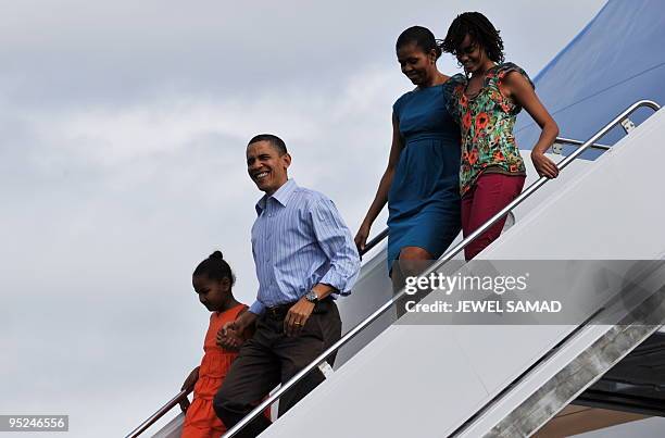 President Barack Obama, First Lady Michelle Obama and their daughters Malia and Sasha disembark from Air Force One upon their arrival at the Hickam...