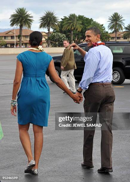 President Barack Obama and First Lady Michelle Obama walk to the motorcade after being greeted in the traditonal Hawaiian way upon their arrival at...