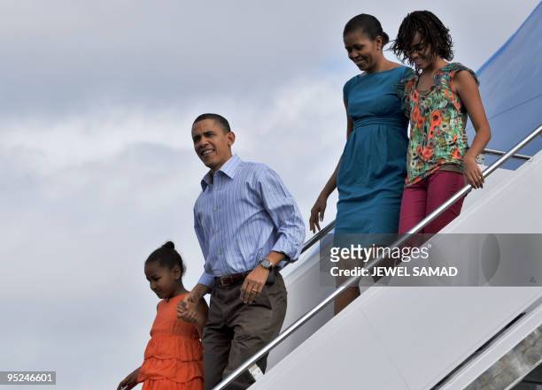 President Barack Obama, First Lady Michelle Obama and their daughters Malia and Sasha disembark from Air Force One upon their arrival at the Hickam...