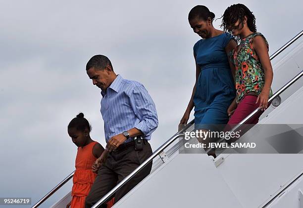 President Barack Obama, First Lady Michelle Obama and their daughters Malia and Sasha disembark from Air Force One upon their arrival at the Hickam...