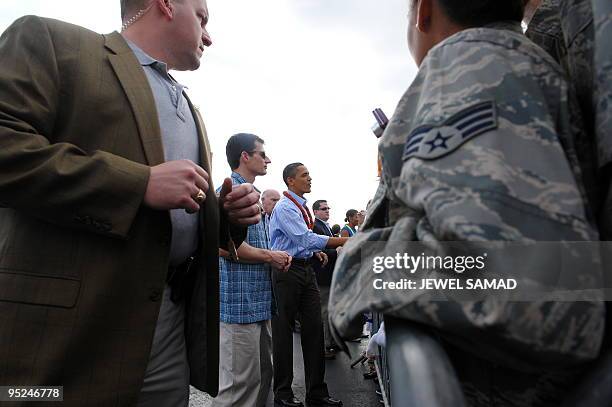 President Barack Obama greets people upon their arrival at the Hickam Air Force Base in Honolulu, Hawaii, on December 24, 2009 for Christmas...