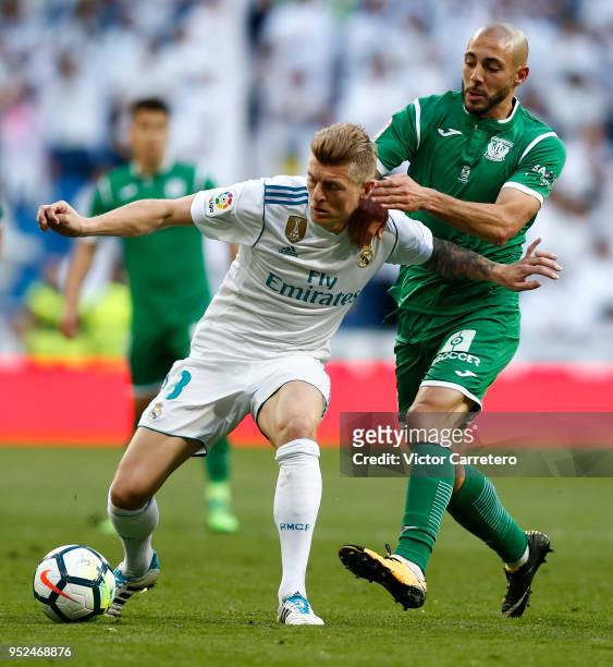 Toni Kroos of Real Madrid competes for the ball with Nabil El Zhar of Leganes during the La Liga match between Real Madrid and Leganes at Estadio...