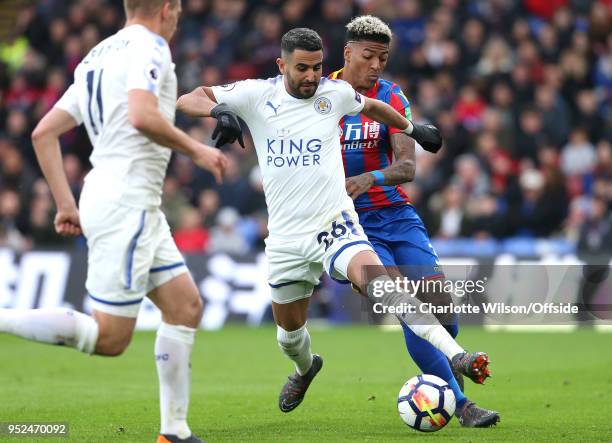 Riyad Mahrez of Leicester and Patrick van Aanholt of Crystal Palace battle for the ball during the Premier League match between Crystal Palace and...