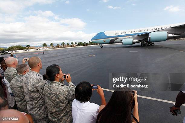 Supporters take photographs of Air Force One as it arrives to Hickam Air Force Base in Honolulu, Hawaii, U.S., on Thursday, Dec. 24, 2009. The first...