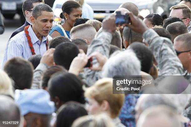 President Barack Obama and First Lady Michelle Obama greets well-wishers at Hickam Air Force Base on December 24, 2009 in Honolulu, Hawaii.