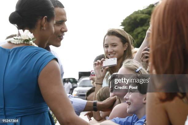 President Barack Obama and First Lady Michelle Obama greet well-wishers at Hickam Air Force Base on December 24, 2009 in Honolulu, Hawaii.