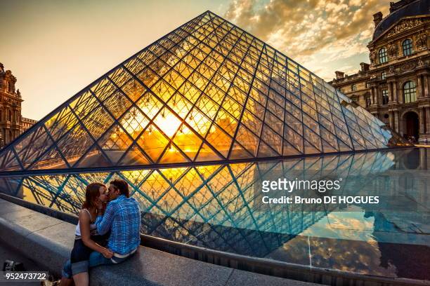 French kiss' devant la Pyramide du Louvre le 8 Juillet 2010, un couple d'amoureux s'embrassant dans la Cour Napoleon, Paris, France.