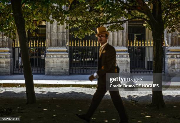 Un homme en chapeau haut de forme traversant le jardin du Palais Royal le 12 Juillet 2013, Paris;France.