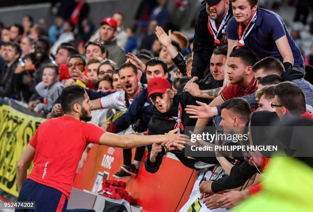 Lille's French forward Yassine Benzia is congratulated by supporters at the end of the French L1 football match between Lille and Metz on April 28...