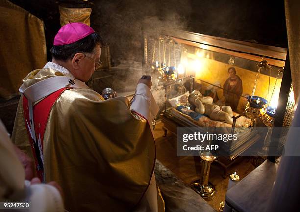 Latin Patriarch of Jerusalem Fouad Twal blesses a statue of the baby Jesus inside in the Grotto where Christians believe the Virgin Mary gave birth...
