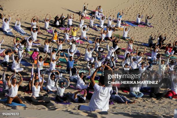 People practice yoga, during a meeting organized by YSYoga System at the Samalayuca desert, Juarez municipality, Chihuahua state, Mexico, on April...