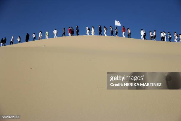 People attend a yoga class, during a meeting organized by YSYoga System at the Samalayuca desert, Juarez municipality, Chihuahua state, Mexico, on...