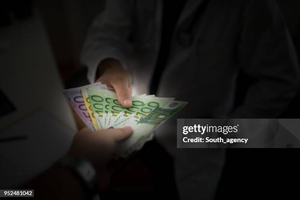 man giving bribe to a doctor - corruption stock pictures, royalty-free photos & images