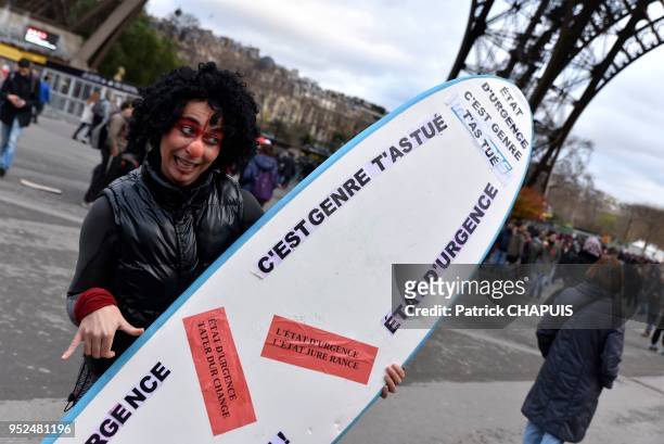 Jeune femme déguisée portant une planche à voile avec des slogans contre l'état d'urgence lors de la manifestation alter-mondialiste en marge du...