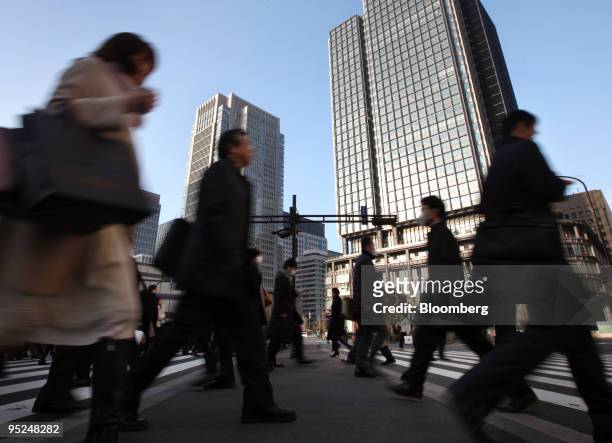 Morning commuters make their way to work in the central business district of Tokyo, Japan, on Friday, Dec. 25, 2009. Japan's unemployment rate rose...