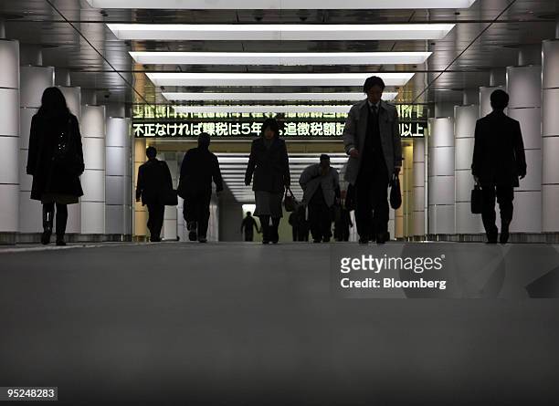 Morning commuters make their way to work in the central business district of Tokyo, Japan, on Friday, Dec. 25, 2009. Japan's unemployment rate rose...