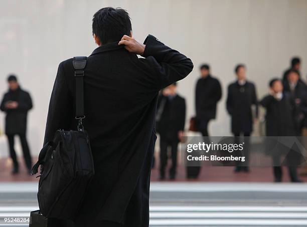 Morning commuters make their way to work in the central business district of Tokyo, Japan, on Friday, Dec. 25, 2009. Japan's unemployment rate rose...