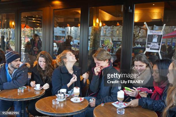 Gens à la terrasse du café 'A la Bonne Bière' lors de sa réouverture le 4 décembre 2015,, 3 semaines après avoir été attaqué par des terroristes,...