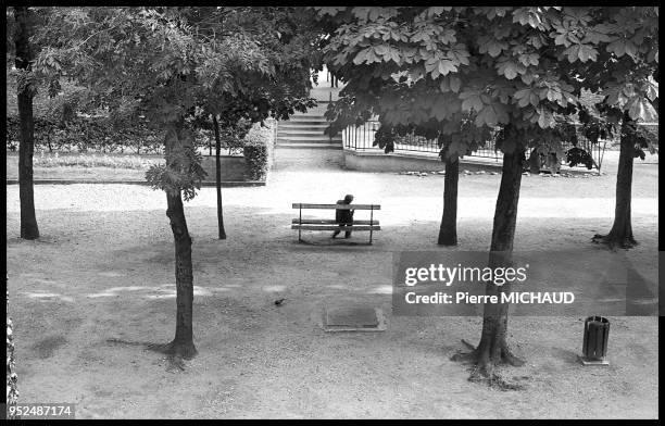 Homme assis sur un banc public dans le jardin des Tuileries, 1994 a Paris, France.