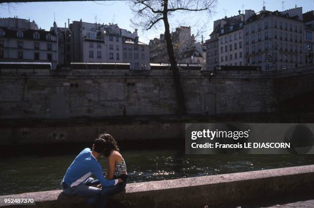 Lovers on a balustrade above the Seine River, Ile de la Cite, 2004 in Paris, France.