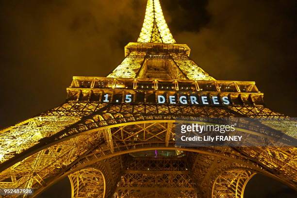 La tour Eiffel de nuit, le dernier jour de la COP21, portant l'inscription '1,5 degrees' pour lutter contre le changement climatique le 12 décembre...