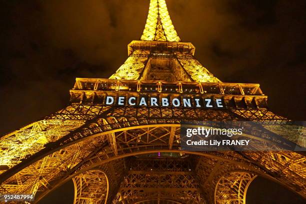 La tour Eiffel de nuit, le dernier jour de la COP21, portant l'inscription 'Decarbonize' pour lutter contre le changement climatique le 12 décembre...